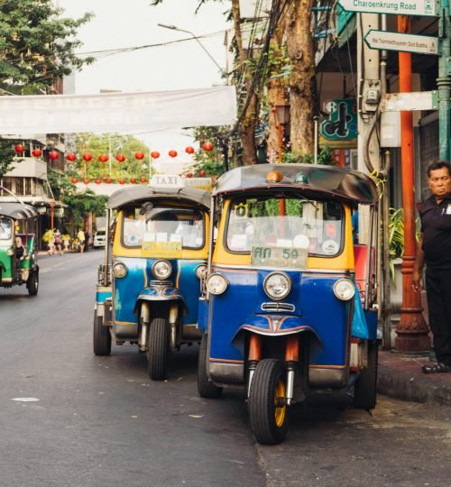 Iconic tuk tuks parked on a bustling street in Bangkok, Thailand