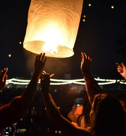 People celebrate by launching a sky lantern at night in Chiang Mai, Thailand.